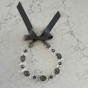 Clear/smoky grey sparkling crystals with light gray ribbon tie.